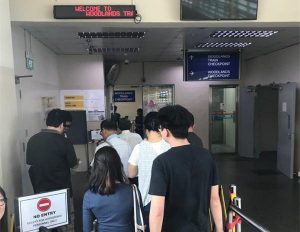 KTM工作人员扫描从新加坡到新山的乘客实体票或电子票